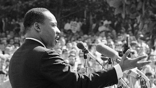 Dr. Martin Luther King Jr. addressing a large crowd.