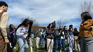students looking at eclipse through telescope