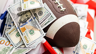 a picture of a football ball with $100 bills thrown on it